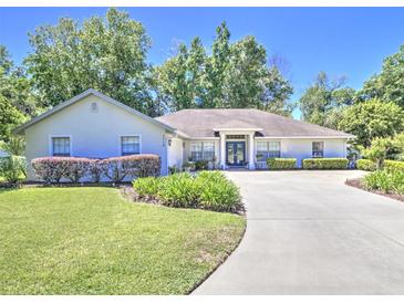 Charming single-story home with a well-manicured lawn and a curved driveway leading to the front entrance at 2410 Se 23Rd Pl, Ocala, FL 34471
