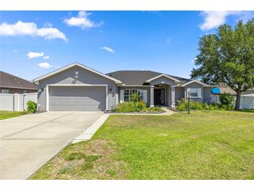Charming single-story home with a well-manicured lawn and a two-car garage at 4939 Sw 99Th Pl, Ocala, FL 34476
