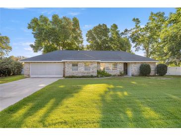 Charming single-story home with a well-manicured lawn and mature trees, offering great curb appeal at 8215 Sw 53Rd Ct, Ocala, FL 34476