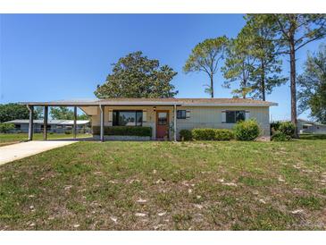Charming single-story home featuring a covered carport and a well-maintained front yard at 10040 Sw 93Rd Ct, Ocala, FL 34481