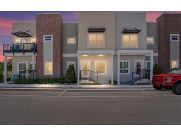 Charming townhouse exterior with modern architectural details, muted color palette, and manicured landscaping at 288 N Oak Ave, Sanford, FL 32771