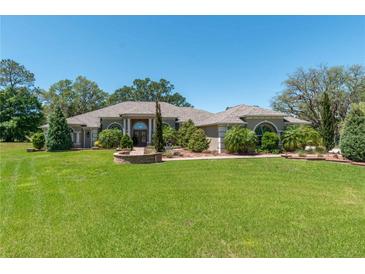 Expansive home features a well-manicured lawn, mature trees, and a circular driveway leading to a grand entrance at 5090 Nw 80Th Avenue Rd, Ocala, FL 34482