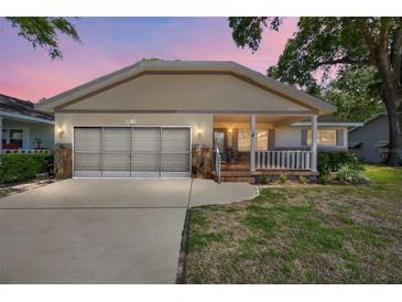Charming single-story home showcasing a covered front porch, and a two-car garage at 8831 Sw 94Th Ln # H, Ocala, FL 34481