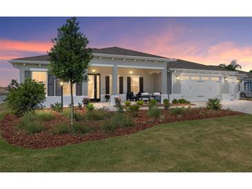 Beautiful single-story home with a welcoming front porch and well-manicured lawn at sunset at 9764 Sw 81St Ln, Ocala, FL 34481