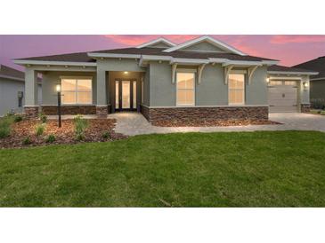 Charming single-story home features a stone accent base, well-maintained lawn, and welcoming walkway at 9945 Sw 83Rd Ln, Ocala, FL 34481