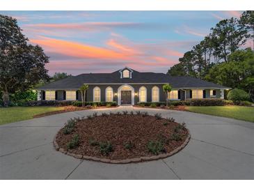 Charming home with a circular driveway highlighted by a colorful sunset at 5484 Sw 30Th Ave, Ocala, FL 34471