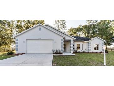 Charming one-story home with attached garage, manicured lawn, and inviting curb appeal at 9525 Sw 53Rd Cir, Ocala, FL 34476