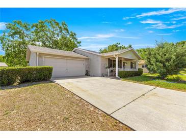 Charming single-story home features a covered porch, two-car garage, and well-maintained landscaping at 10989 Sw 86Th Ave, Ocala, FL 34481