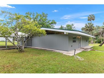 Charming exterior view of the home featuring well-maintained lawn and mature landscaping at 11065 Ne 42Nd St, Silver Springs, FL 34488