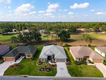 An aerial view of multiple homes with well-maintained lawns in a community with a golf course at 2008 Palo Alto Ave, The Villages, FL 32159