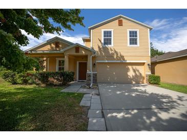 Charming two-story home with a well-manicured lawn and attached two-car garage at 5128 Grassy Knoll Dr, Tavares, FL 32778