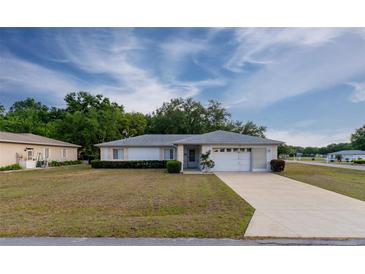Charming single-story home featuring a well-manicured lawn, an attached two-car garage, and a neatly landscaped yard at 6150 Sw 103Rd Loop, Ocala, FL 34476