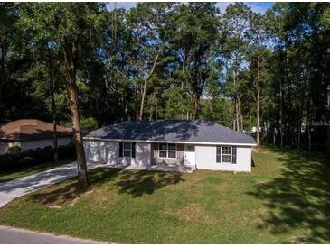 Charming single-story home with a well-manicured lawn and mature trees surrounding the property at 6432 Nw 64Th Ter, Ocala, FL 34482