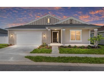 Charming single-story home featuring a two-car garage and a well-manicured lawn at 7827 Sw 56Th Pl, Ocala, FL 34474