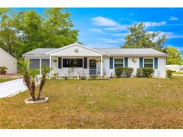 Charming single-story home with a welcoming front porch and well-maintained lawn at 10824 Sw 90Th Ter, Ocala, FL 34481