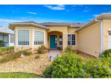 Charming single-story home featuring a colorful front door and neat landscaping at 11799 Se 173Rd Lane Rd, Summerfield, FL 34491