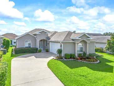 Charming single-story home boasts a well-manicured lawn, lush landscaping, and a curving driveway at 2323 Nw 55Th Avenue Rd, Ocala, FL 34482