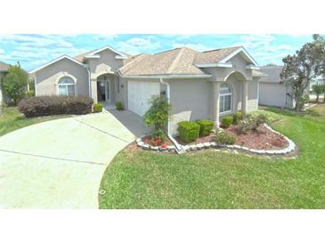 Charming single-story home featuring a well-manicured lawn, inviting entrance, and attached two-car garage at 2323 Nw 55Th Avenue Rd, Ocala, FL 34482