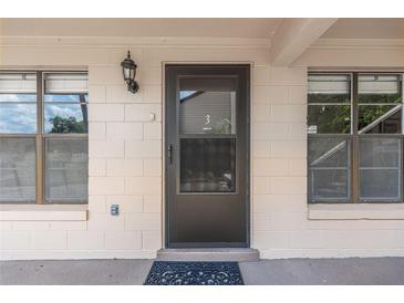 Inviting front door entrance with sidelight windows and exterior lantern lighting fixture at 2433 Ne 7Th St # 3, Ocala, FL 34470