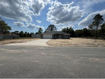 Charming single-story home boasts a spacious front yard and a wide driveway leading to an attached two-car garage at 4162 Sw Gardenia Ct, Dunnellon, FL 34431