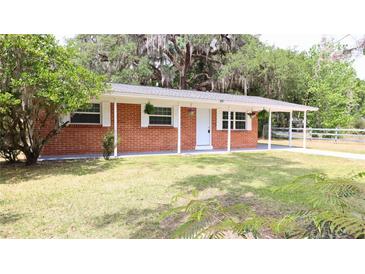 Charming brick home with covered front porch and beautifully manicured lawn at 1335 Ne 10Th St, Ocala, FL 34470