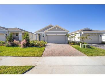 Charming single-story home features a manicured lawn, brick driveway, and attached two-car garage at 5430 Nw 46Th Lane Rd, Ocala, FL 34482