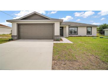 Charming one-story home featuring a two-car garage, lush lawn, and neutral exterior at 60 Walnut Dr, Ocala, FL 34480