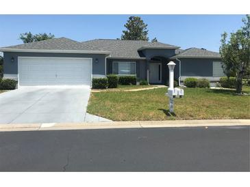 Charming single-story home with well-maintained lawn, gray roof and a two-car garage at 11411 Sw 138Th Ln, Dunnellon, FL 34432