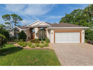 Stunning home with a beautiful lawn, landscaping, and a paved driveway leading to an attached two-car garage at 6882 Sw 113Th Pl, Ocala, FL 34476