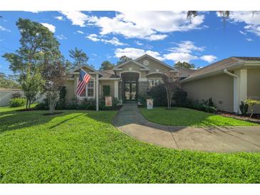 Charming single-story home with a lush green lawn, beautiful landscaping, and a welcoming walkway to the front door at 811 Se 49Th Ave, Ocala, FL 34471