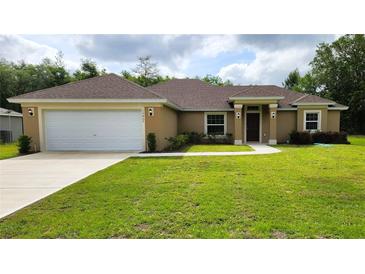 Charming single-story home with a well-manicured lawn and an attached two-car garage at 15407 Sw 59Th Avenue Rd, Ocala, FL 34473