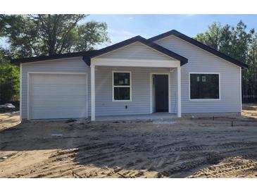 Charming single-story home featuring light gray siding and a covered front porch at 1610 Sw 152Nd Ct, Ocala, FL 34481