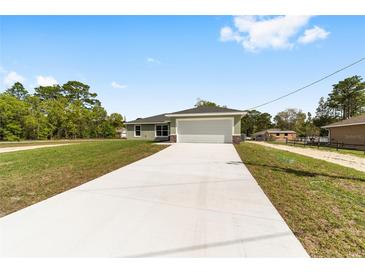 Charming single-story home with a spacious driveway and attached two-car garage at 2114 W Magenta Dr, Citrus Springs, FL 34434