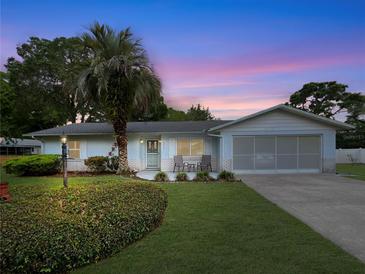 Charming single-story home featuring well-maintained landscaping, a palm tree, and an attached garage, perfect for suburban living at 2340 Ne 44Th St, Ocala, FL 34479