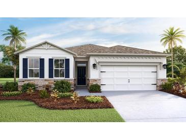 Charming one-story home featuring a two-car garage, stone accents and well manicured landscaping at 3080 Canopy Oak Blvd, Wildwood, FL 34785
