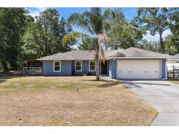 Charming single-story home with a spacious lawn and a two-car garage at 3112 Se 140Th Ln, Summerfield, FL 34491