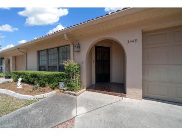 Charming home featuring an arched entryway, well-maintained landscaping, and convenient attached garage at 3449 Sw 19Th St, Ocala, FL 34474
