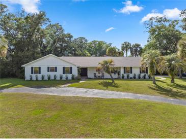 Charming single-story home boasts a well-manicured lawn and a circular driveway at 400 Se 45Th Ter, Ocala, FL 34471