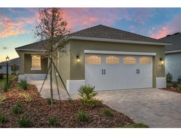 Charming home with an attached garage, verdant lawn, and manicured landscaping at 10347 Sw 99Th Ln, Ocala, FL 34481