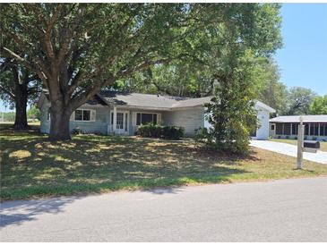 Quaint single-story home with mature trees in the front yard offers a cozy curb appeal at 11025 Sw 64Th Ave, Ocala, FL 34476