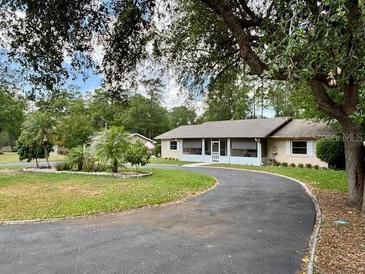 Charming single-story home boasts an extended driveway, lush greenery, and a serene setting at 4145 Se 3Rd St, Ocala, FL 34471