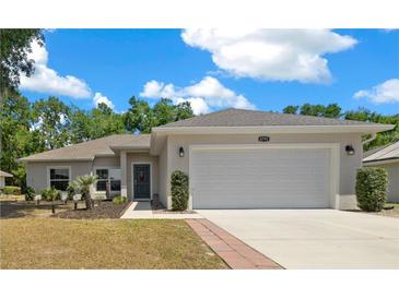 Charming single-story home with a well-manicured lawn, two-car garage, and inviting front entrance at 6791 Se 100Th Pl, Belleview, FL 34420
