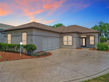 Charming home featuring a circle driveway with a decorative star inlay and well manicured landscaping at 11945 Se 171St Loop, Summerfield, FL 34491
