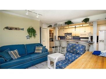 Bright living room showcases blue furnishings, coastal decor, and an open view into the kitchen at 20820 River Dr # B25, Dunnellon, FL 34431