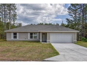 Charming single-story home featuring a well-maintained lawn, attached two car garage, and a welcoming entrance at 22913 Sw Edgewater Blvd, Dunnellon, FL 34431