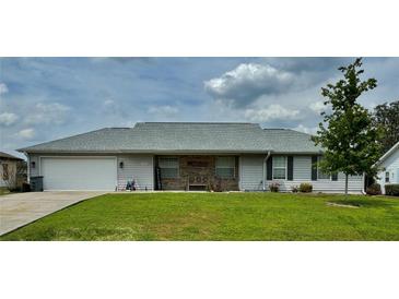 Charming single-story home with a well-manicured lawn, gray roof, and inviting front porch at 4513 Nw 30Th Pl, Ocala, FL 34482