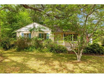 Charming home featuring blue shutters and inviting curb appeal with lush greenery surrounding the property at 608 Se 31St Ter, Ocala, FL 34471