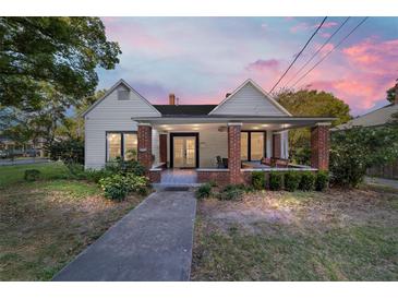 Charming home with a covered front porch, brick pillars, and a well-maintained landscaped yard at 716 Se Wenona Ave, Ocala, FL 34471