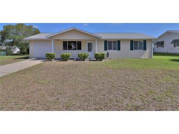 Charming single-story home featuring a well-maintained lawn and a welcoming front porch at 8443 Sw 109Th Place, Ocala, FL 34481