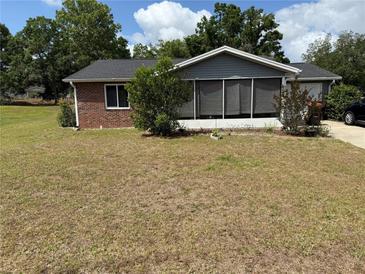 Charming single-story brick home featuring a screened-in porch and well-maintained landscaping at 8556 Sw 109Th Lane Rd, Ocala, FL 34481